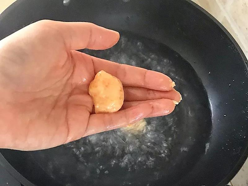 手沾清水，抓鸡肉泥团成丸子形状。