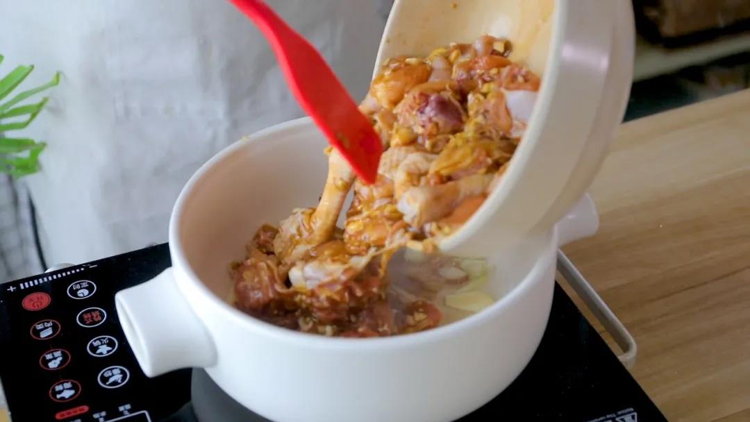 放入腌制好的鸡肉铺好，盖上盖子中火焖煮