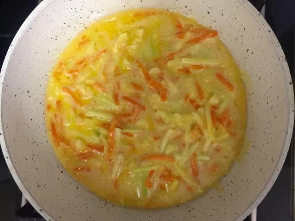 第5步：锅里刷油，倒入面糊后表面撒奶酪碎，小火煎制。