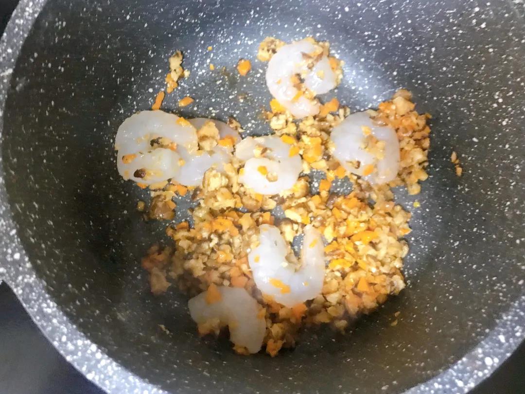 香菇、胡萝卜切碎，和虾仁一起入油锅翻炒至虾仁变色。