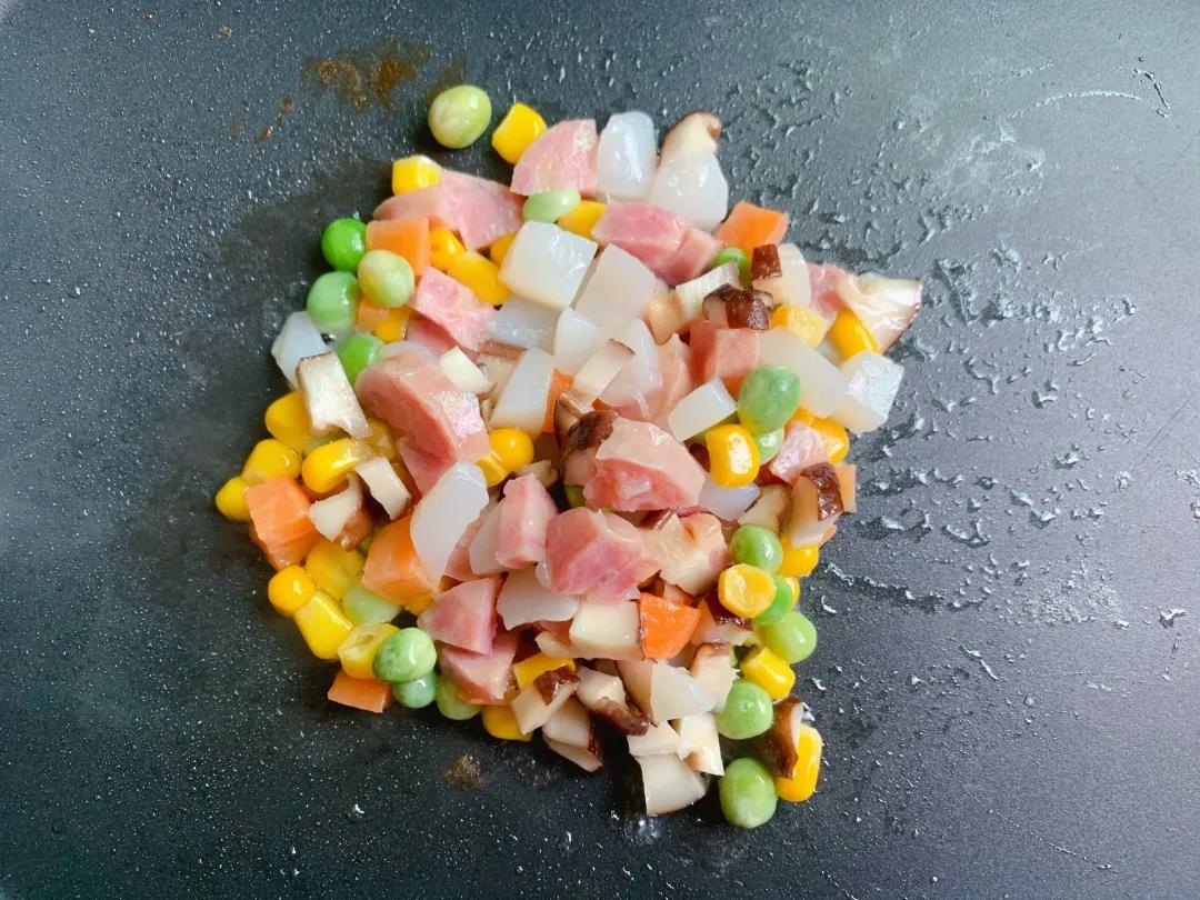 肉肠丁、扇贝柱、杂菜、香菇入油锅翻炒至熟。