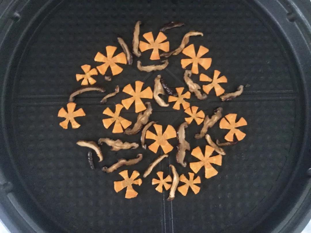 第4步：胡萝卜、香菇切片，入油锅炒熟后在锅底铺成圆形。