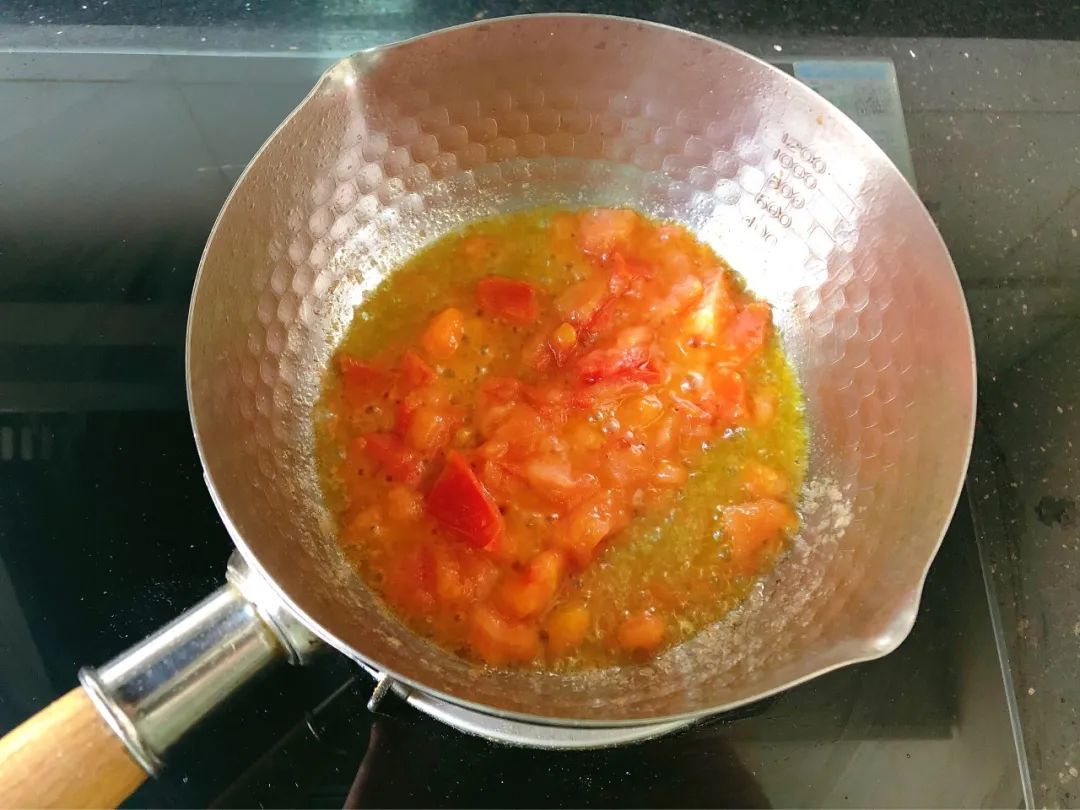 西红柿洗净去皮切丁，入油锅翻炒出汁。