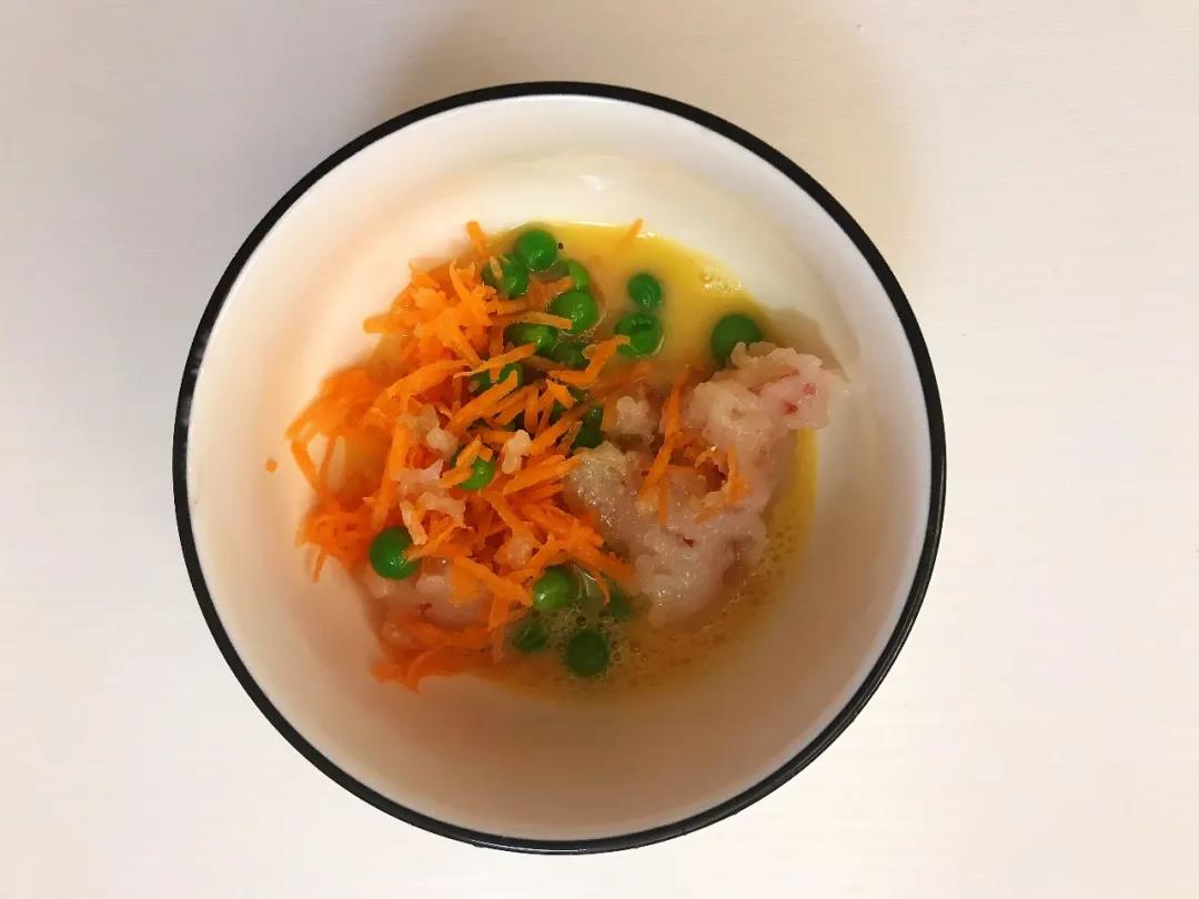 第4步：鸡蛋洗净取蛋黄打散，放入豌豆、胡萝卜碎、虾泥和油，搅拌均匀。