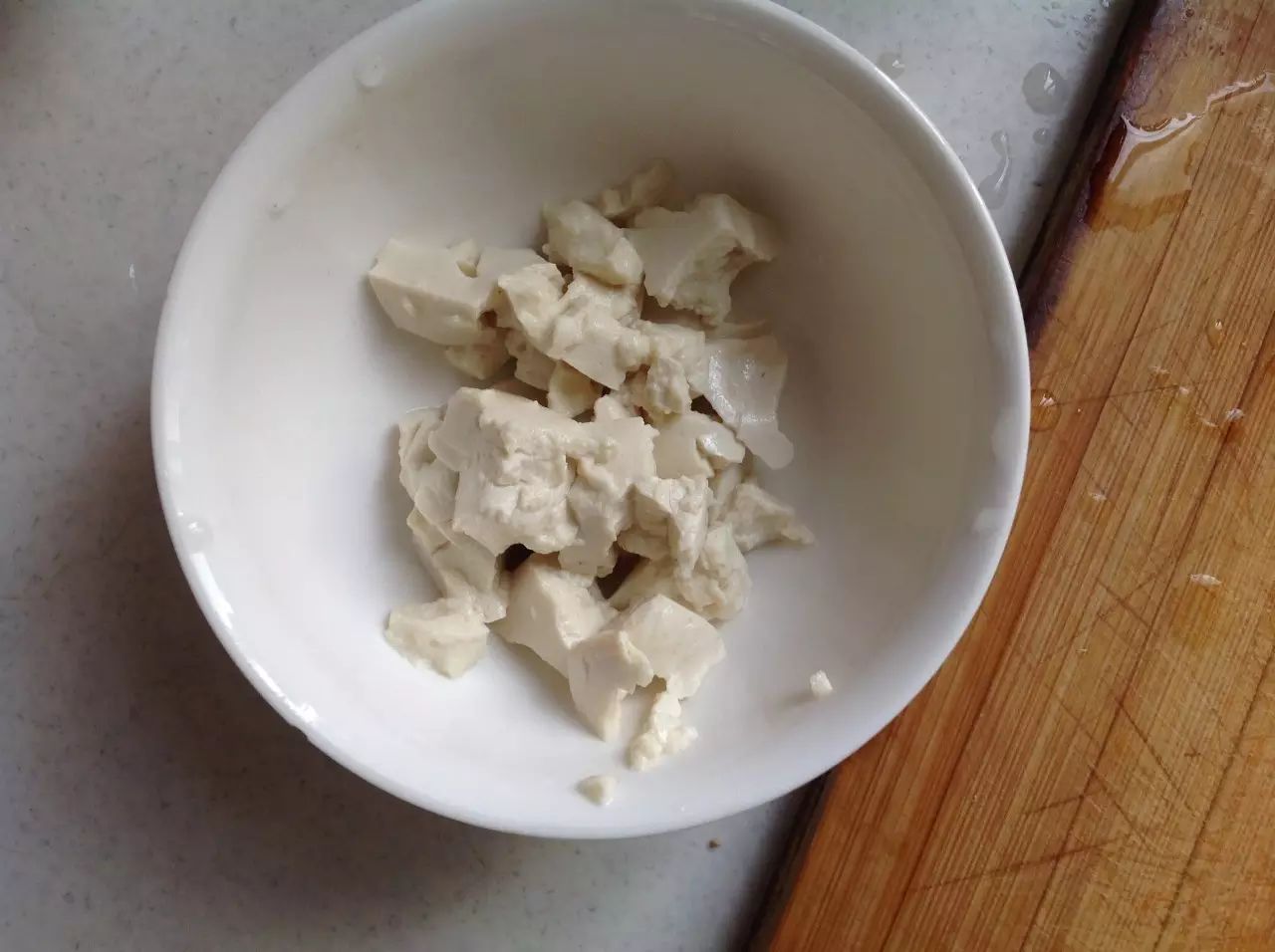 蒸螃蟹的时候准备其他材料。豆腐沸水煮3分钟捞出压碎。