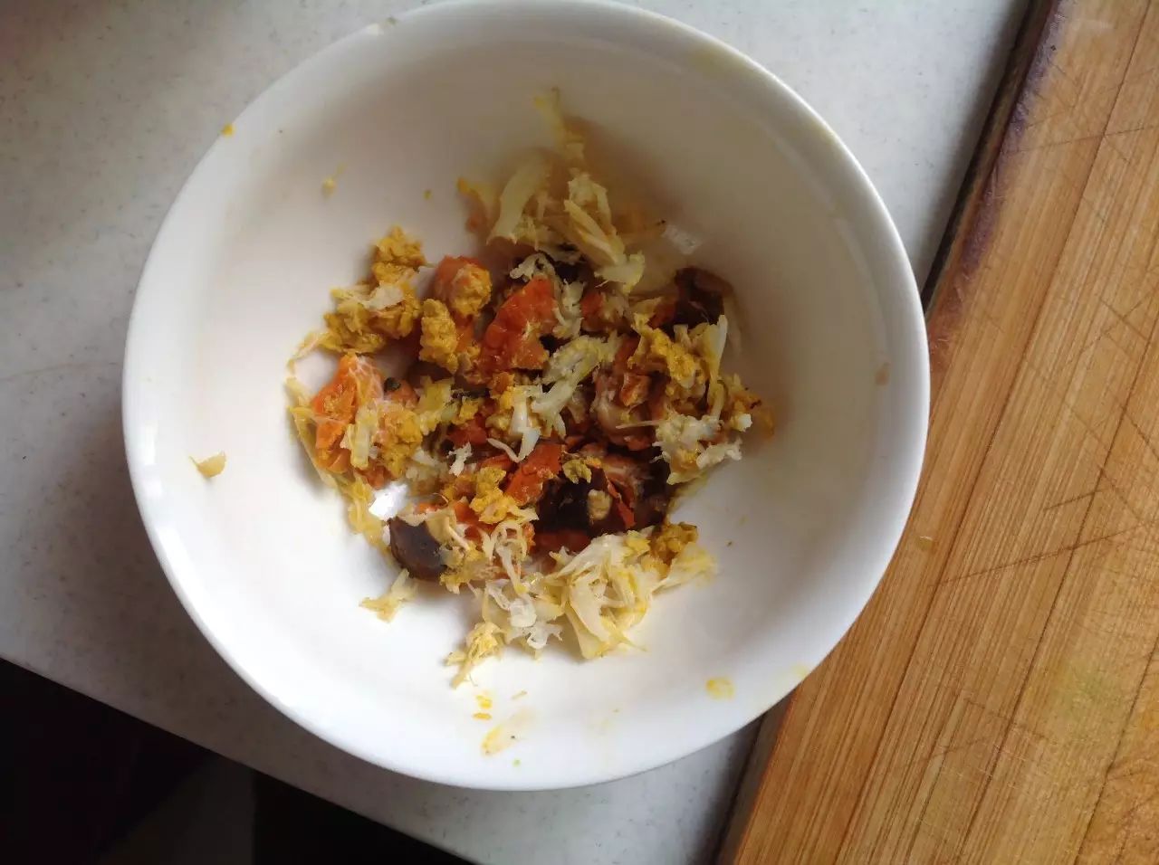 取出蒸熟的螃蟹，剥下少许蟹黄。