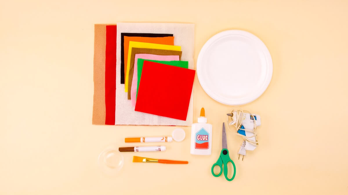 步骤1：材料准备：纸盘子、白胶、胶枪、标记、剪刀、瓶盖(或可追踪的圆形物品)、毛毡 - 各种颜色适合您不同的浇头!我们用浅棕色 (13”x13”) 做比萨饼皮，用红色和白色 (7.5”x7.5”) 做番茄酱和奶酪，还有粉色、绿色、黄色、深棕色、橙色和黑色做其他配料!