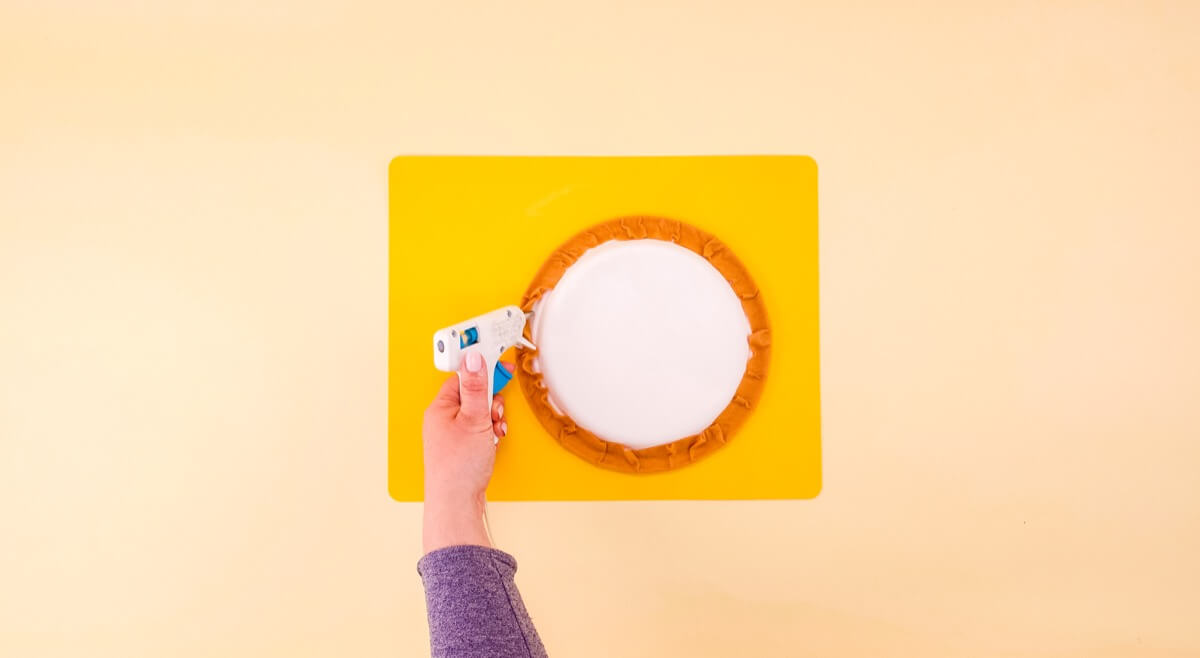 步骤5：用胶枪胶水，将多余的毛毡粘在盘子边缘的底部，以完成你的外壳！让我们做一些披萨配料吧！ 