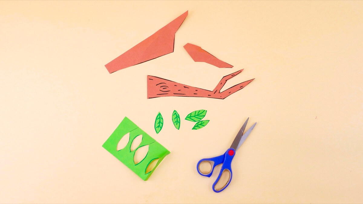 步骤3：制作蜂巢悬挂的树枝和叶子。用棕色建筑纸剪下一个树枝，用绿色建筑纸剪下一些叶子。使用记号笔或蜡笔添加一些细节。