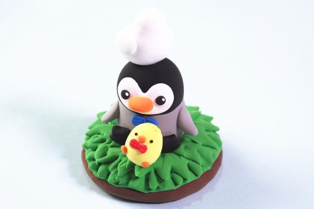 步骤11：用白色粘土做一只小母鸡粘在企鹅的头顶。