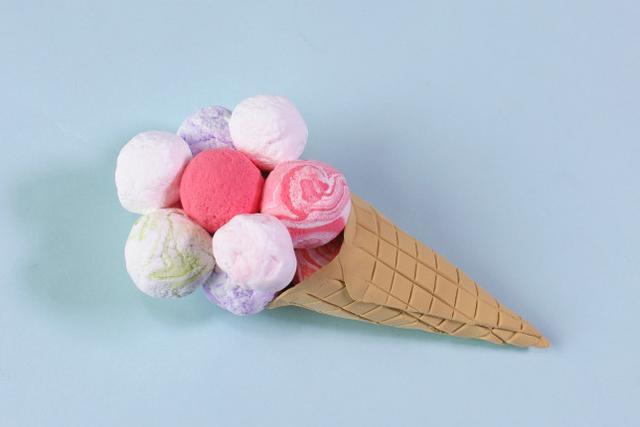 步骤7：再做出一些不同颜色的圆球粘在冰激凌筒上做好造型，然后用七本针在小球上面戳出小孔。