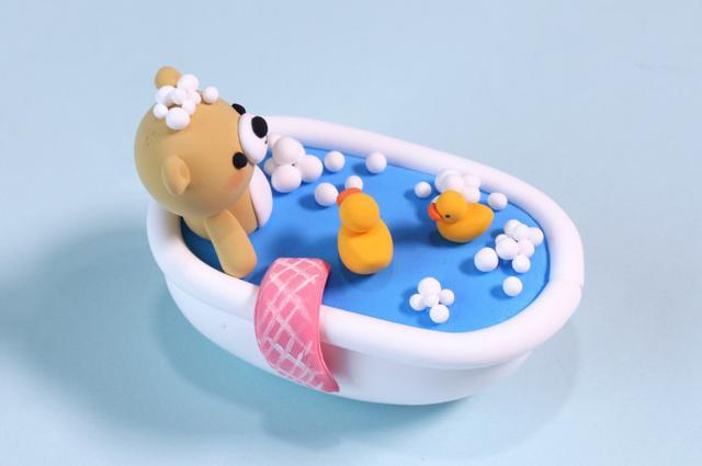 步骤9：用粉红色粘土做一块浴巾，上面用白色笔画出格子做装饰。