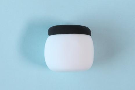 步骤6：下面做身体，用白色粘土做一个圆柱形，然后顶部粘上一片黑色圆片。