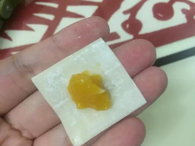 将少量馅料放在馄饨皮中间。