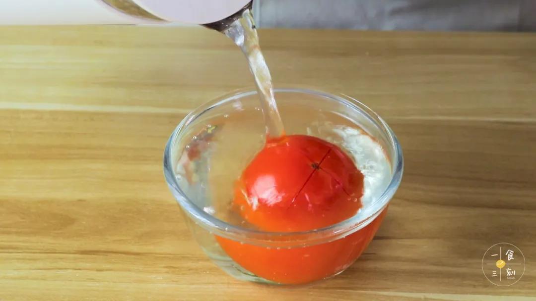 番茄底部切十字，倒入开水浸泡，然后撕去表皮