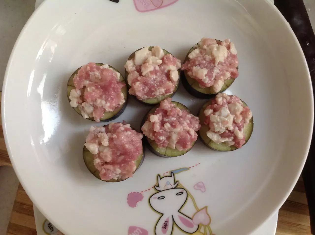 将豆腐肉末涂抹在茄子上。