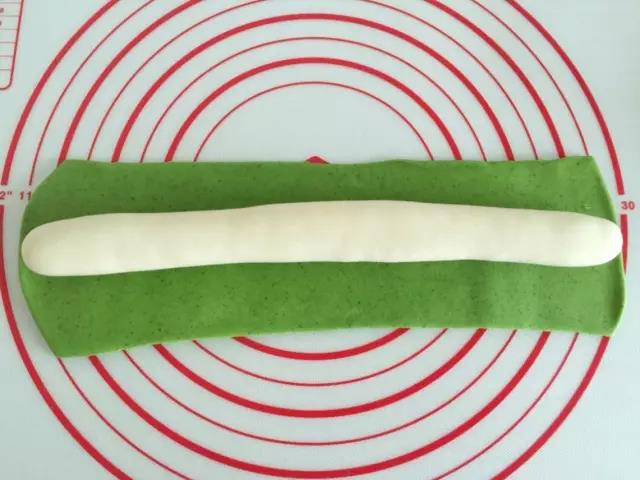 把绿色面团擀开，白色放在里面。