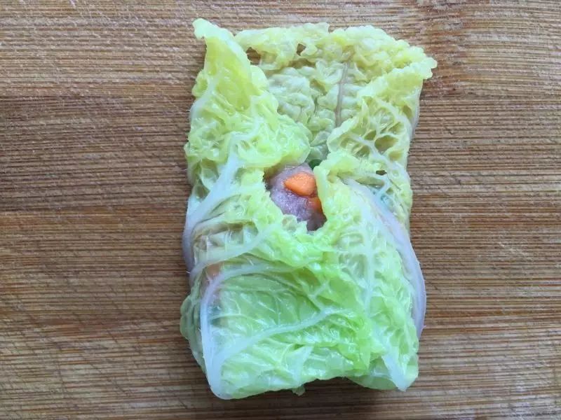 再将左右两边的菜叶向中间折。