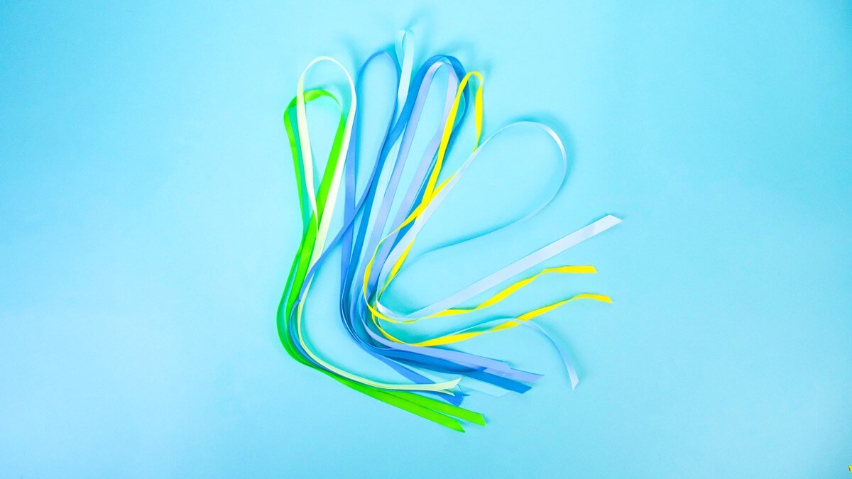 步骤5：组装时，用你的拉链领带做一个环（我们稍后会关闭环）并将末端粘在桌子上。当您将丝带系在环上时，这将有助于将环固定到位，使其更容易一些！