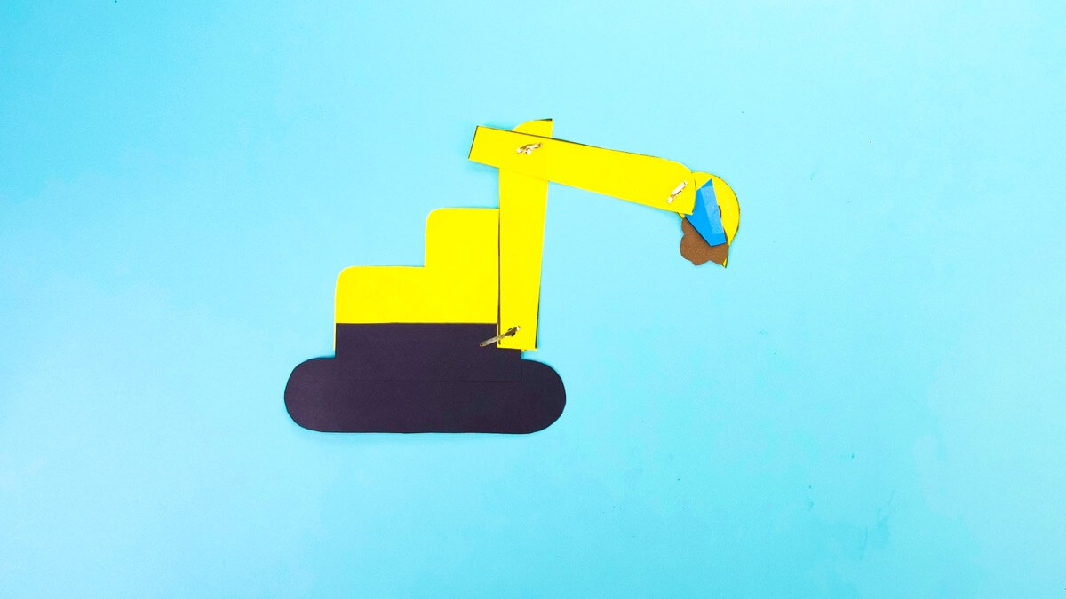 步骤10：最后，将您的挖掘机翻转过来，在铲斗的背面添加一个口袋，用于存放挖掘材料。剪出一个适合水桶背面的小形状，并在一侧用胶带将其固定到位。这个纠察队可以固定你的挖掘材料并将其倾倒！ 