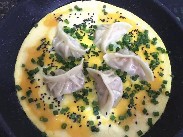 第12步：小火烘至蛋液成型，表面未熟前撒黑芝麻和葱花，烘熟鸡蛋即可。