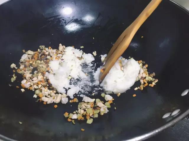 肉泥下锅翻炒至变色后倒入米饭翻炒均匀，出锅冷却备用。