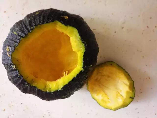 挑选一只合适的小南瓜，连外皮一起洗干净，用勺子掏出瓜瓤和籽。