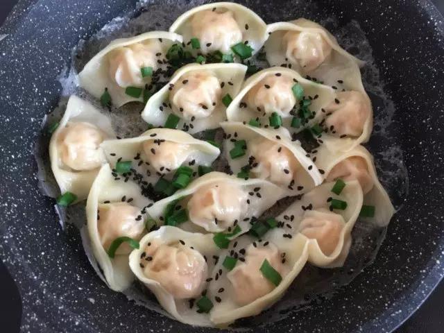 倒入清水没过馄饨，大火烧开转小火焖煎至水烧干，倒入少许淀粉水，煎至底部焦脆，撒上小葱和芝麻即可出锅。