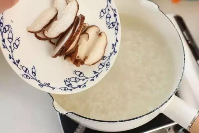 大米加入10倍的水，大火烧开后改中小火熬制软烂，倒入香菇。