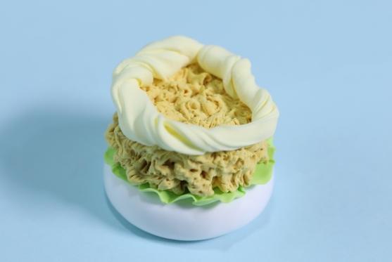 步骤4：用乳白色粘土拧出细条做成环状粘在鸡肉饼上，这是沙拉。