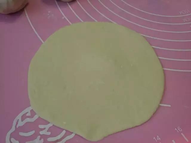 第6步：擀面棍从外向内擀成中间厚旁边薄的面皮。