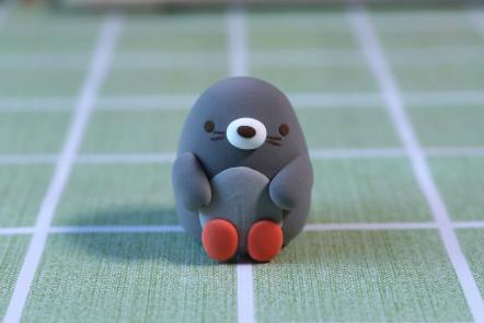 步骤9：大红色粘土揉两个小圆球作为双脚，然后做出两只胳膊，做好造型。