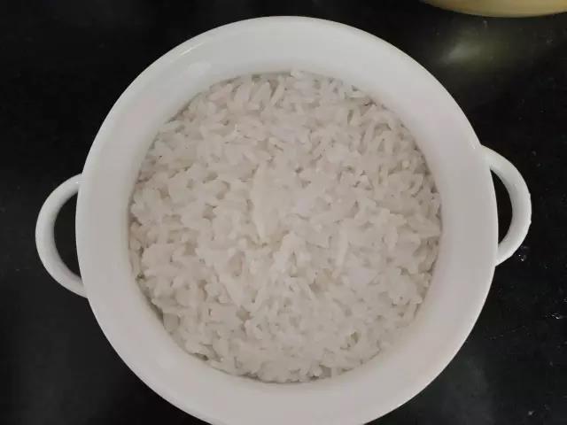 米饭铺在烤碗内，用勺子稍微压一下。