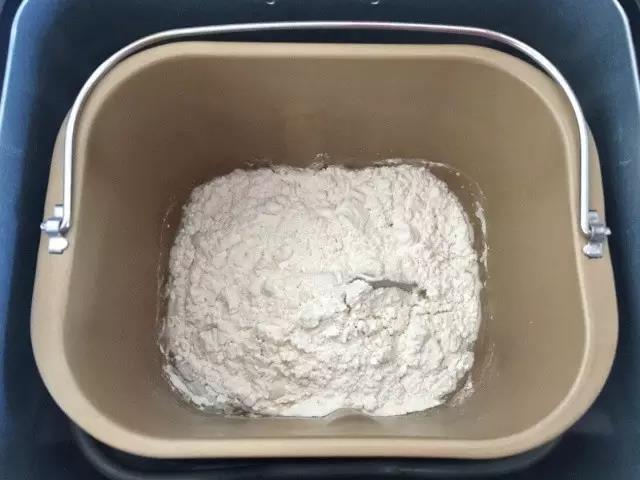 第1步：把面粉、水、酵母放进面包机。