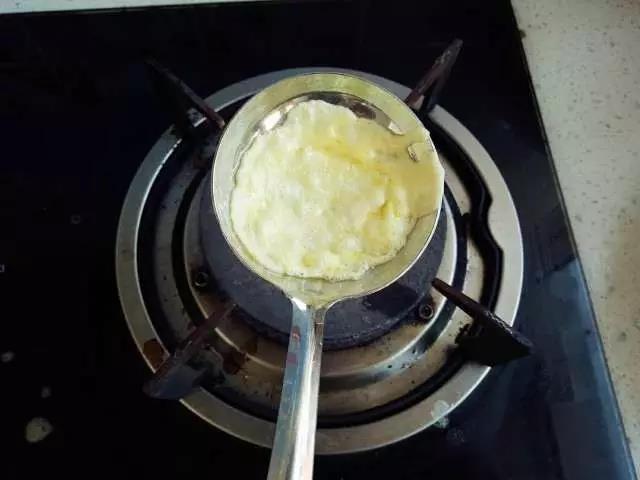 煤气灶开小火，取1把不锈钢勺子擦少许油烧温热，倒入少量蛋液晃动摊成薄的蛋皮。