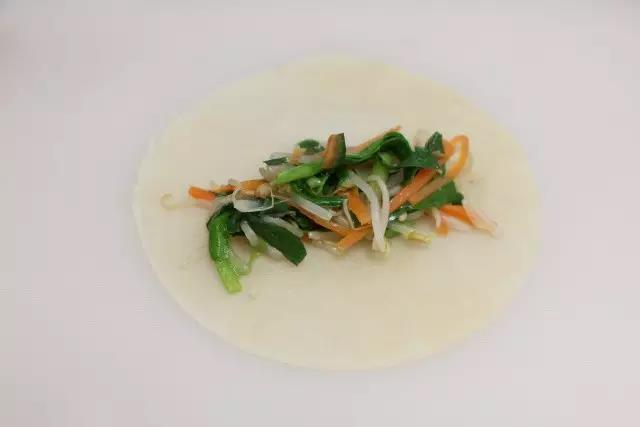 第16步：将菜放在饼皮上卷起来即可。