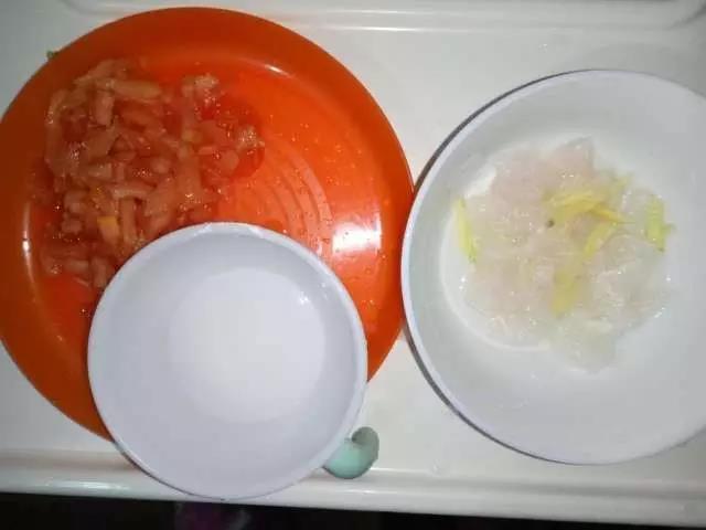 西红柿去皮切丁，巴沙鱼切丁，生姜切丝放到巴沙鱼丁中腌制15分钟，淀粉加少许清水搅拌均匀。