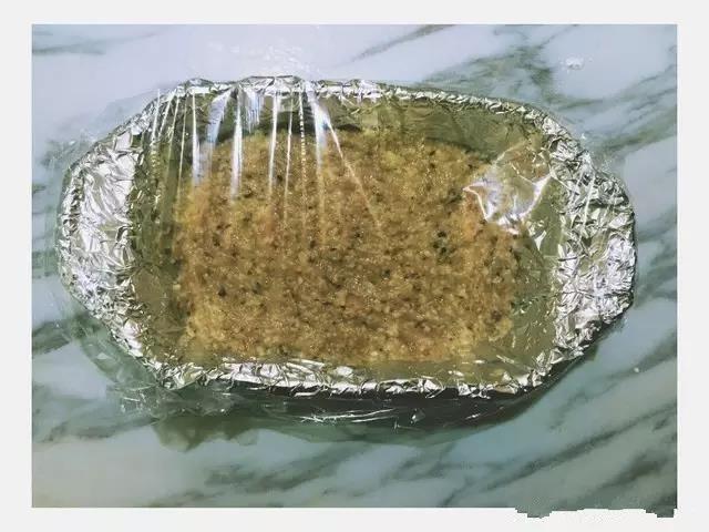 蒸碗内铺一层锡纸，然后把肉泥放入碗中，用勺子摊平，敷一层保鲜膜，用牙签扎几个小孔。