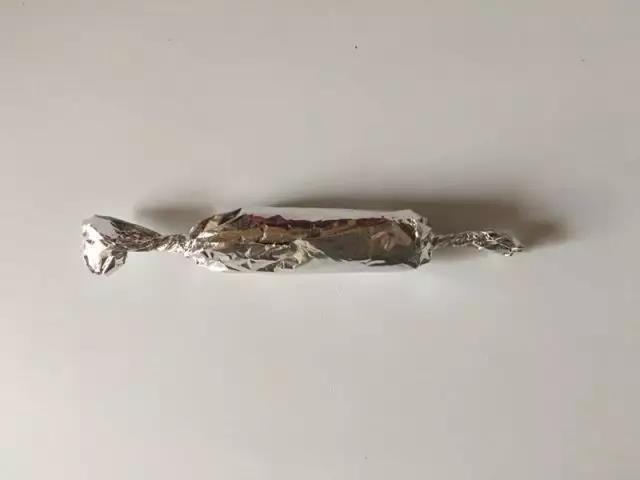 像卷糖果一样：轻轻卷起锡纸拧住两边。