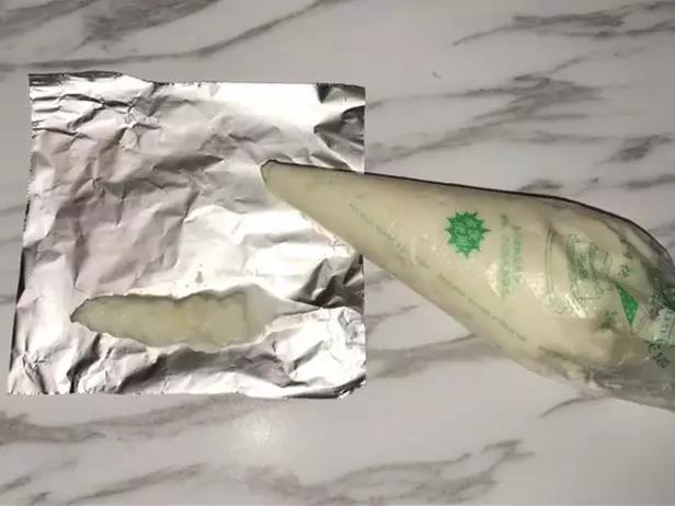 第5步：把混合泥装进裱花袋内，挤出适量大小在锡纸上包住。