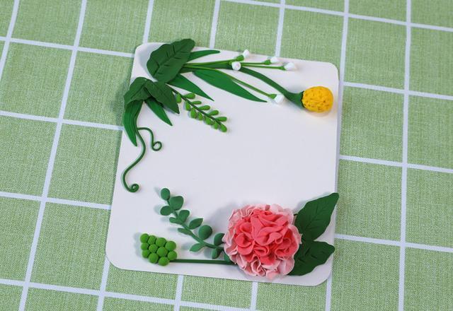 步骤12：把做好的花朵粘在右下角的绿叶上面。