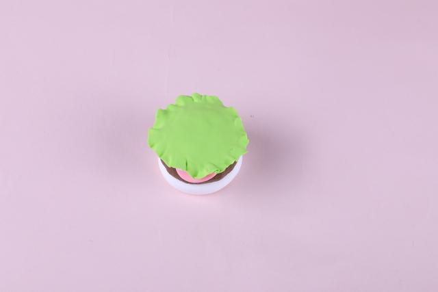 步骤5：用绿色粘土做成圆形薄片，边缘扯出生菜叶子的形状。