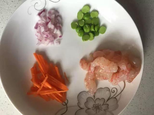 准备食材，胡萝卜去皮切细条，豌豆去皮，洋葱切丁，虾仁洗净。