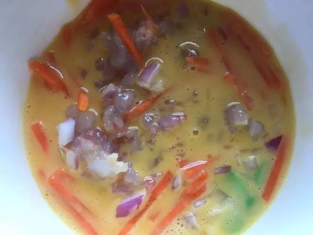 把胡萝卜、豌豆、洋葱、虾仁倒入步骤2中的蛋液里，搅匀。