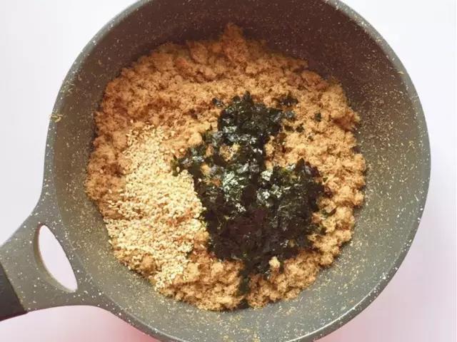 把肉松倒入锅内，加入海苔碎、芝麻，翻炒两三分钟，晾凉即可。