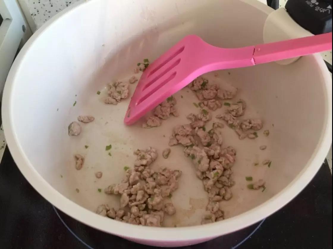 第5步：锅里倒少许油，炒香葱末后倒入肉末翻炒。