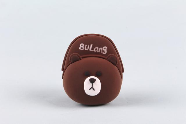 步骤5：然后用褐色粘土揉成细条做成背包的拉链。在背包上面用白色笔写上字作为装饰。