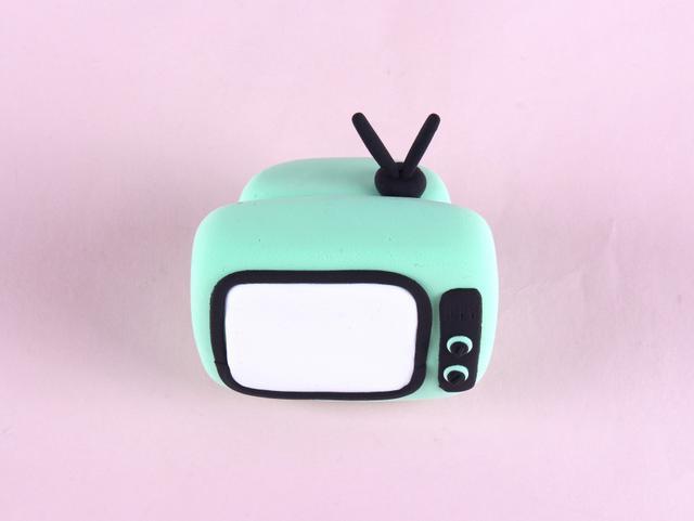 步骤7：然后再用黑色粘土做出天线粘在电视机顶部。