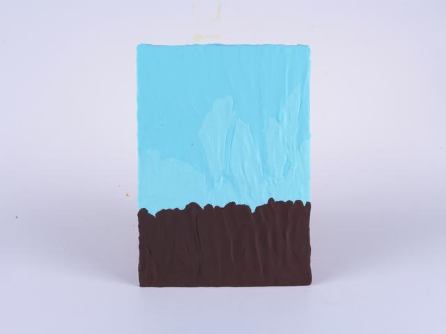 步骤2：背景板上我们用蓝色粘土铺出天空，褐色粘土铺出大地的颜色。