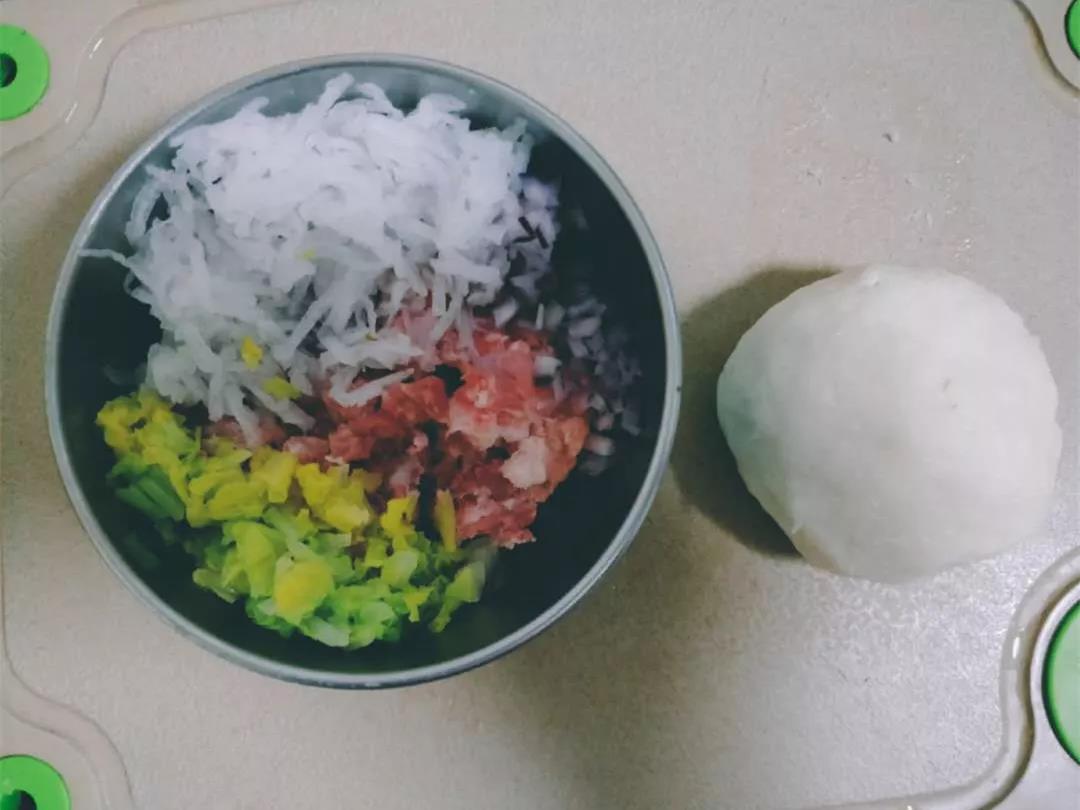 将白萝卜擦成丝，娃娃菜焯水后剁碎，洋葱剁碎，混合猪肉馅，加少许盐搅拌均匀，面粉加入温水揉光醒发30分钟。